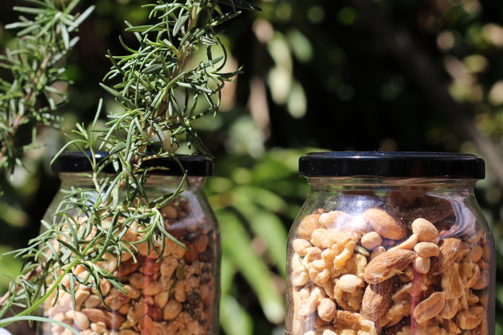 detail of two glass jars with grains such as peanuts, chestnuts and walnuts for selling the product at an outdoor market.