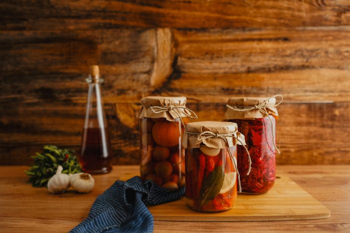 Rustic kitchen scene with preserved vegetables in jars