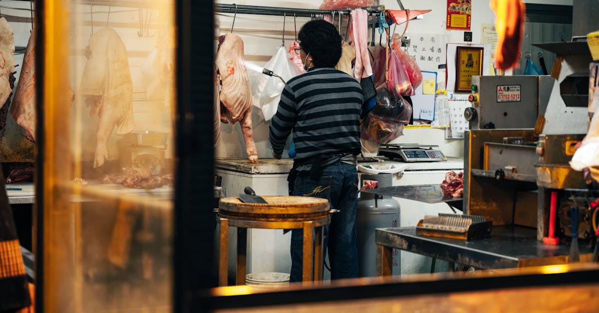 a butcher processes meat inside a traditional shop with hanging cuts