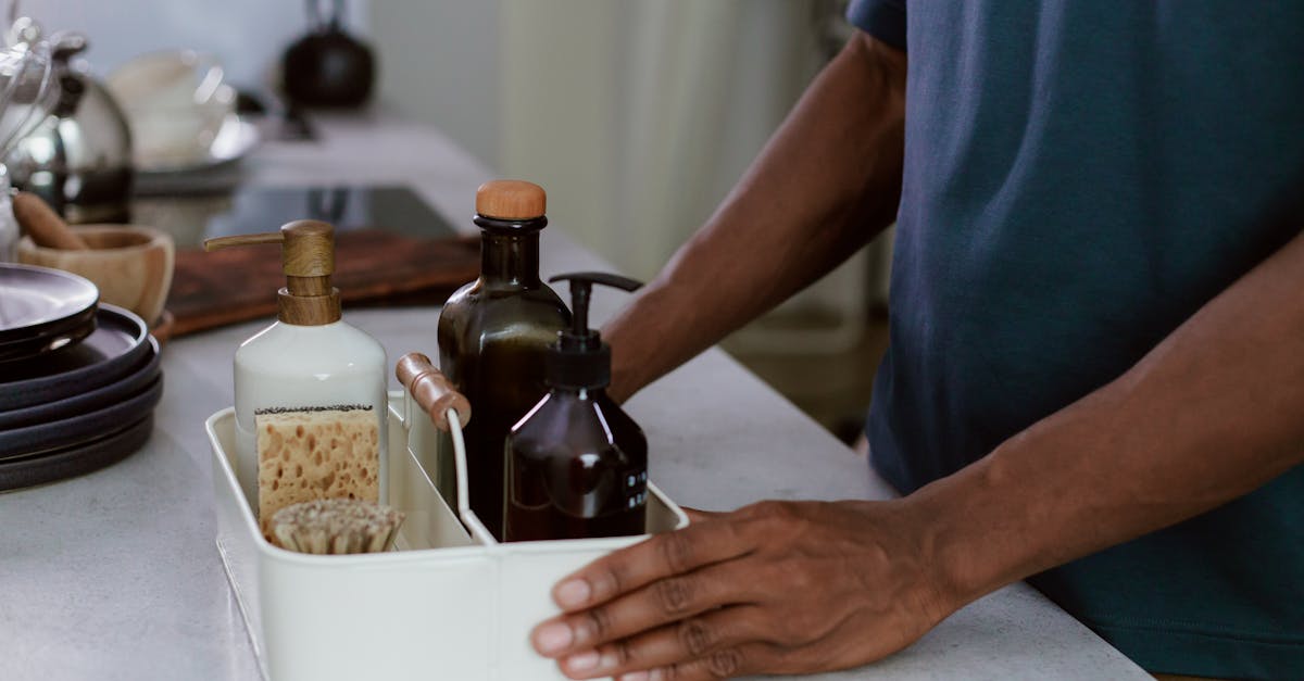 a close up of a man organizing cleaning products in a modern kitchen environment