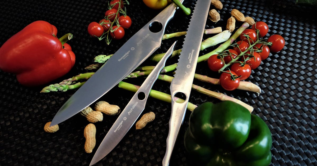 a collection of chef s knives with peppers tomatoes and peanuts on a black surface