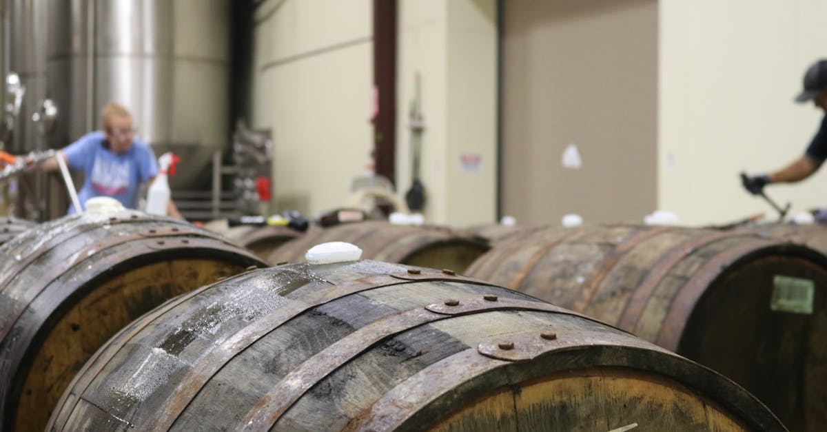 a distillery interior featuring wooden barrels workers are busy in the background showcasing the p