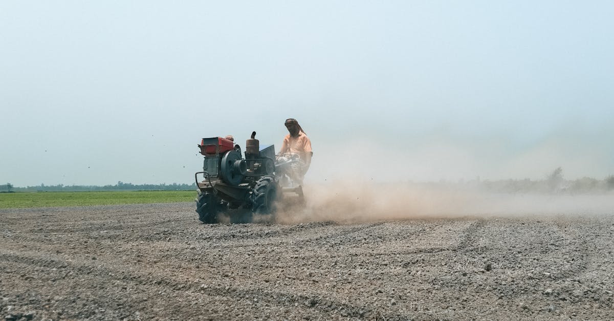 a farmer operates a tractor to plow a dusty field in pabna bangladesh capturing rural agricultural