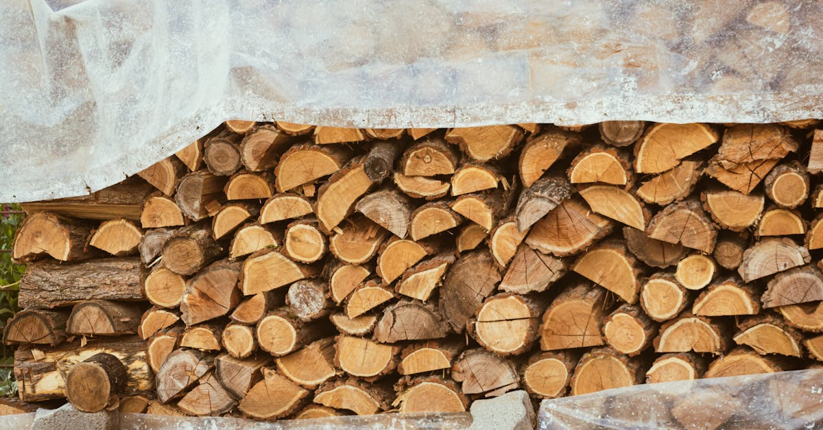 a neatly stacked pile of chopped wood under plastic ready for use