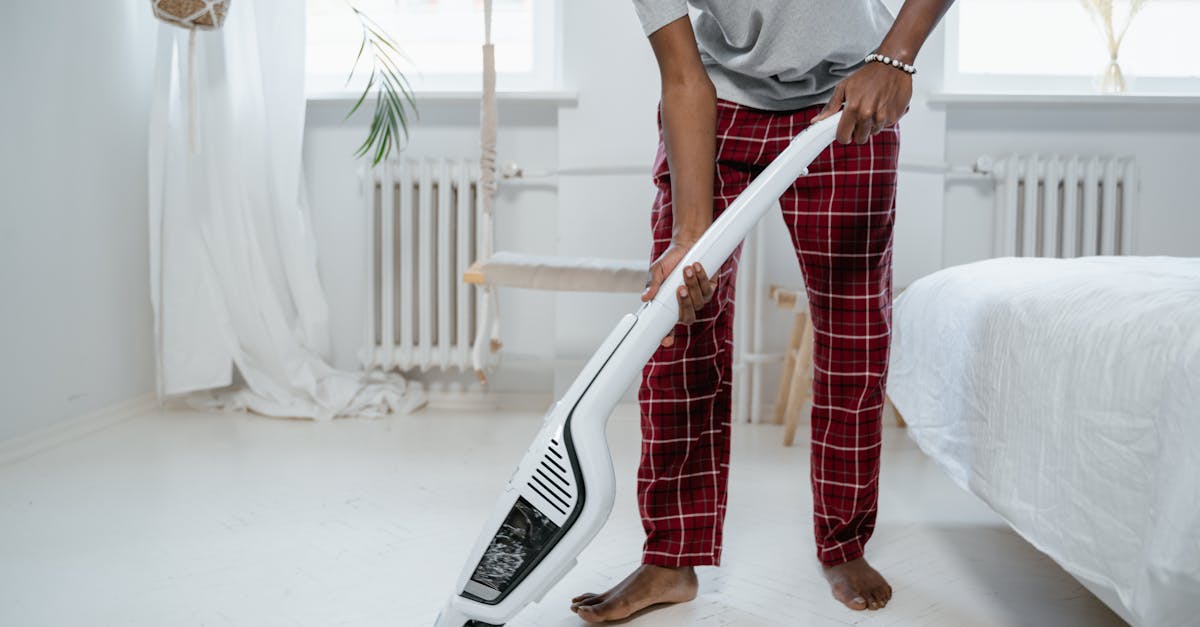 a person cleaning a bedroom with a modern vacuum cleaner showcasing casual home lifestyle