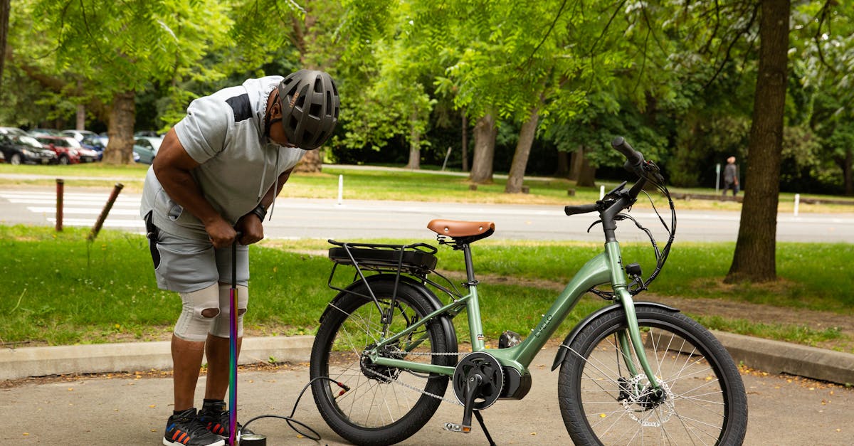 adult man inflates an electric bike tire in a park setting showcasing an active lifestyle