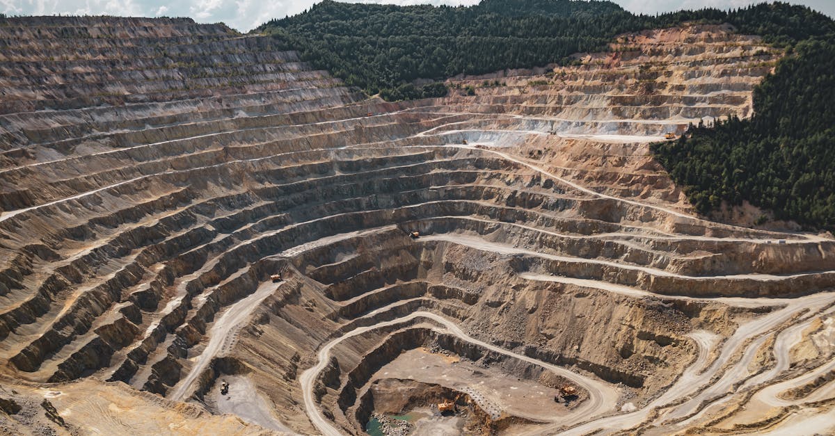 aerial view of a large open pit mine with terraced excavation during summer