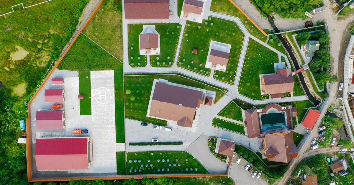 aerial view of modern residential area with helipad surrounded by greenery