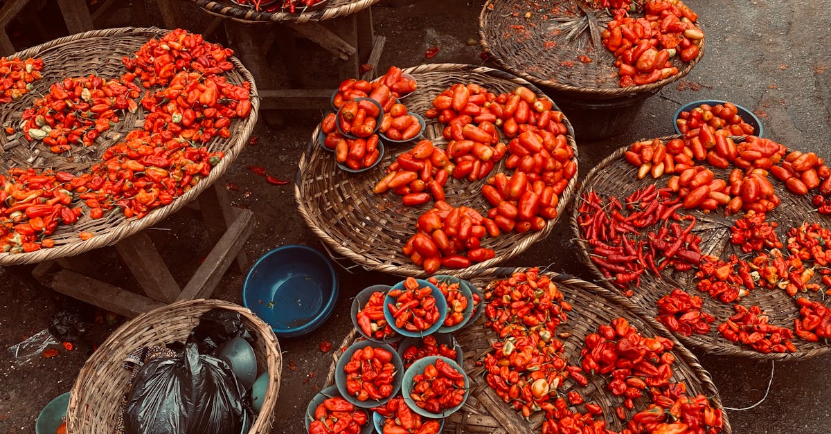 array of vibrant red peppers in baskets at an outdoor market perfect for food and spice themes