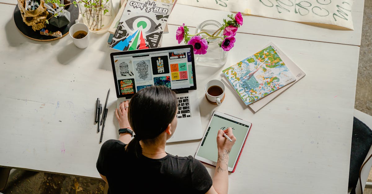 artistic workspace featuring calligraphy and digital design on a tablet and laptop