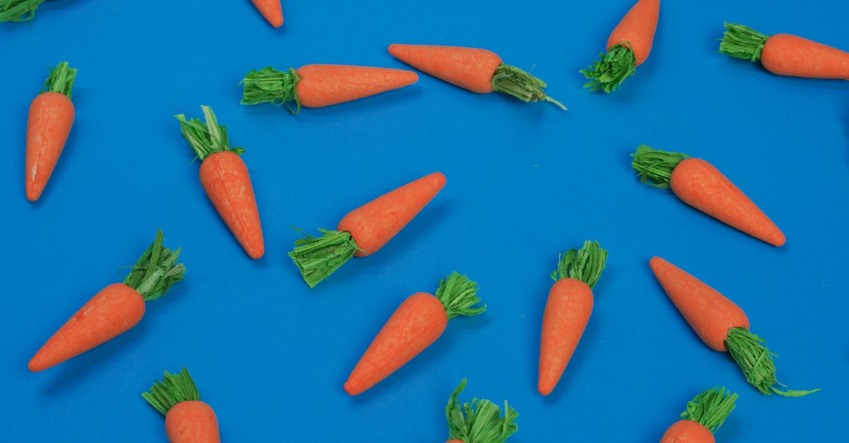 bright carrots arranged on a vibrant blue surface in a flatlay style