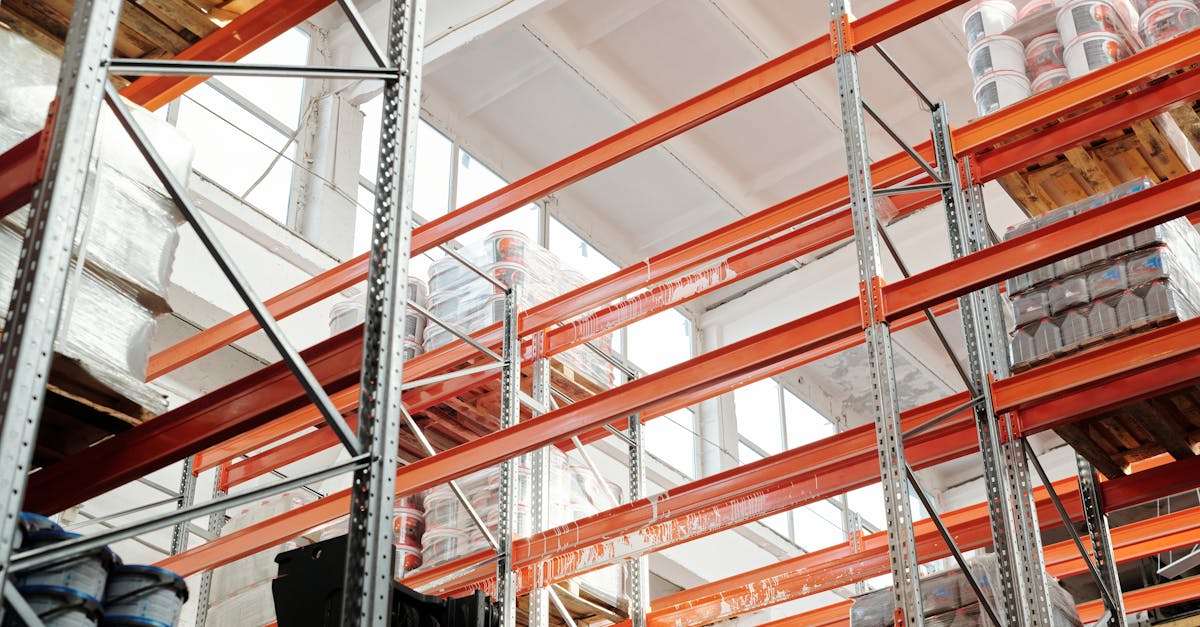 bright warehouse interior with orange metal shelving units and stored goods