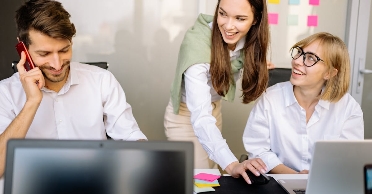 business professionals collaborating at a meeting with laptops and notes in a modern office setting