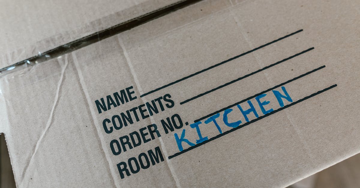 cardboard box labeled with room destination for kitchen during moving process