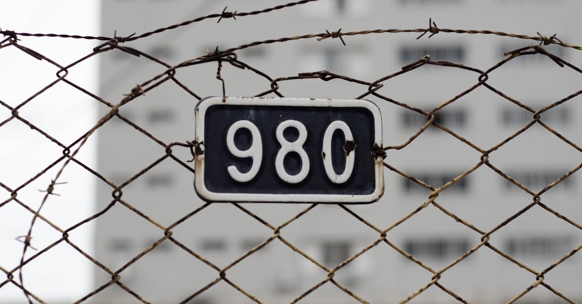 close up of a barbed wire fence with a metal number plate symbolizes security and restriction