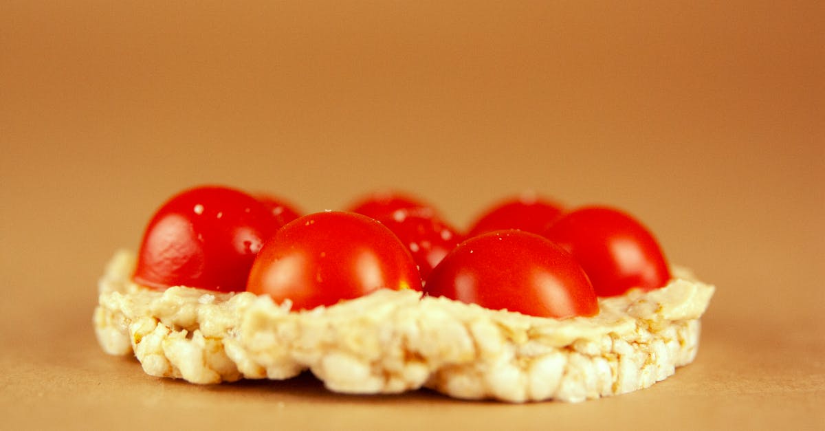 close up of cherry tomatoes on a rice cake set against a neutral golden background ideal for food p