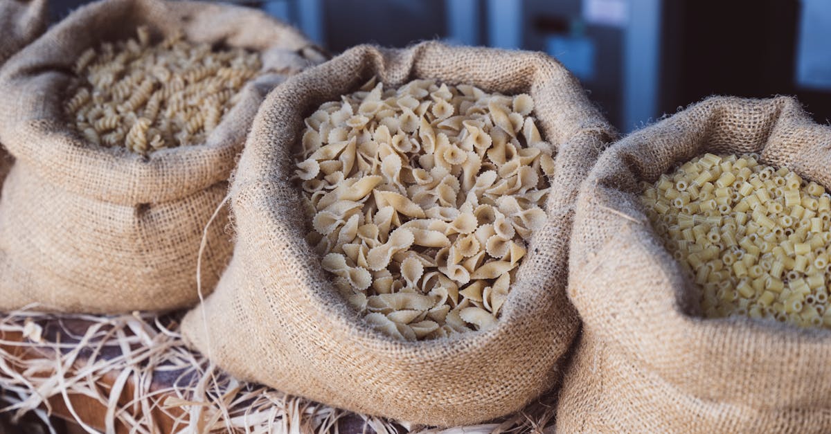 close up of different types of dry pasta in burlap sacks at a market display