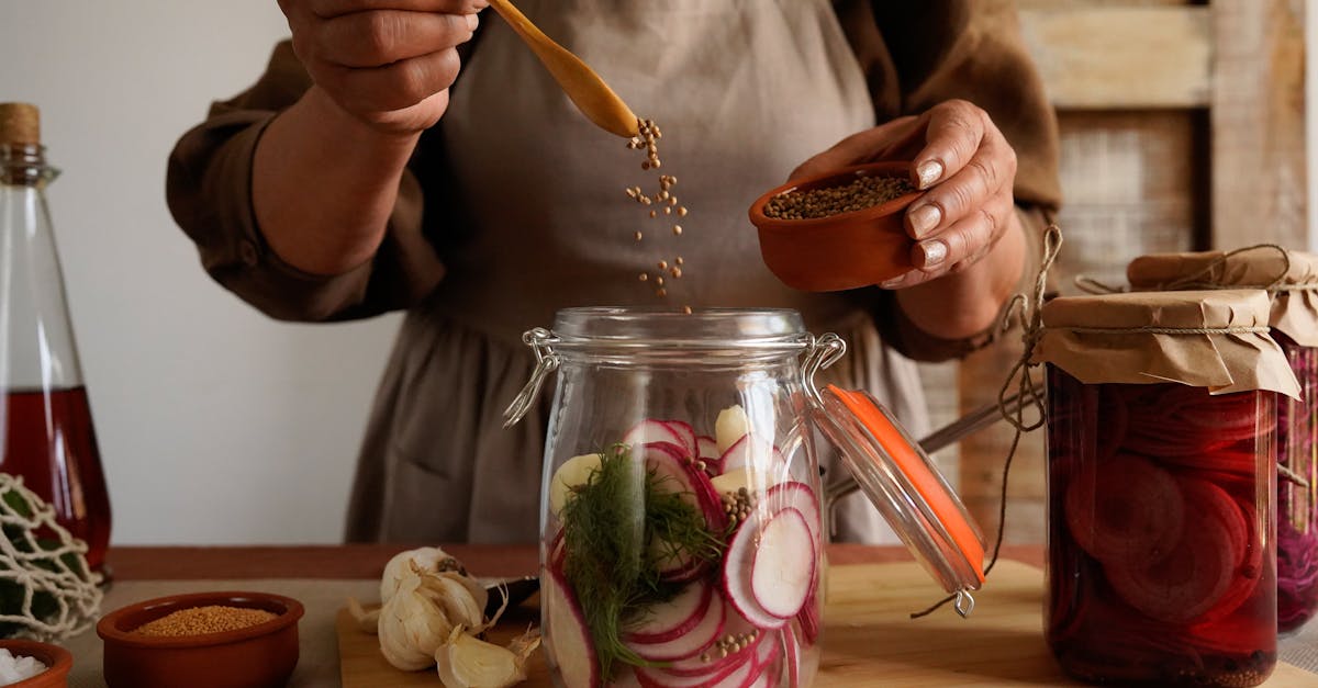 close up of hands preparing homemade pickles with spices in a rustic kitchen setting