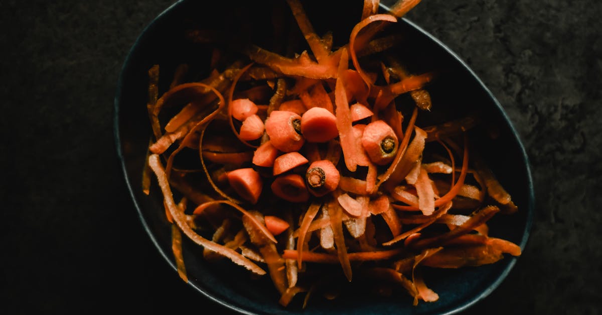 close up photo of fresh carrot peels and scraps in a dark bowl perfect for food waste or preparatio 1