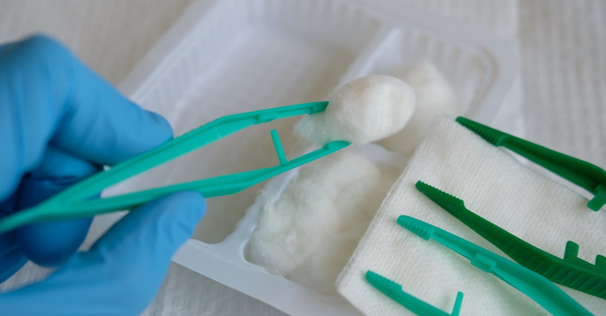 close up view of medical tools including plastic forceps and cotton balls ideal for healthcare cont