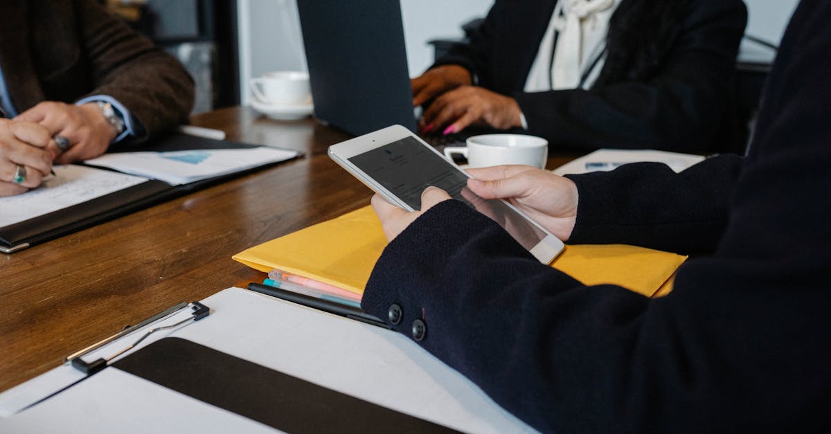 diverse business team collaborating with technology at a table indoors