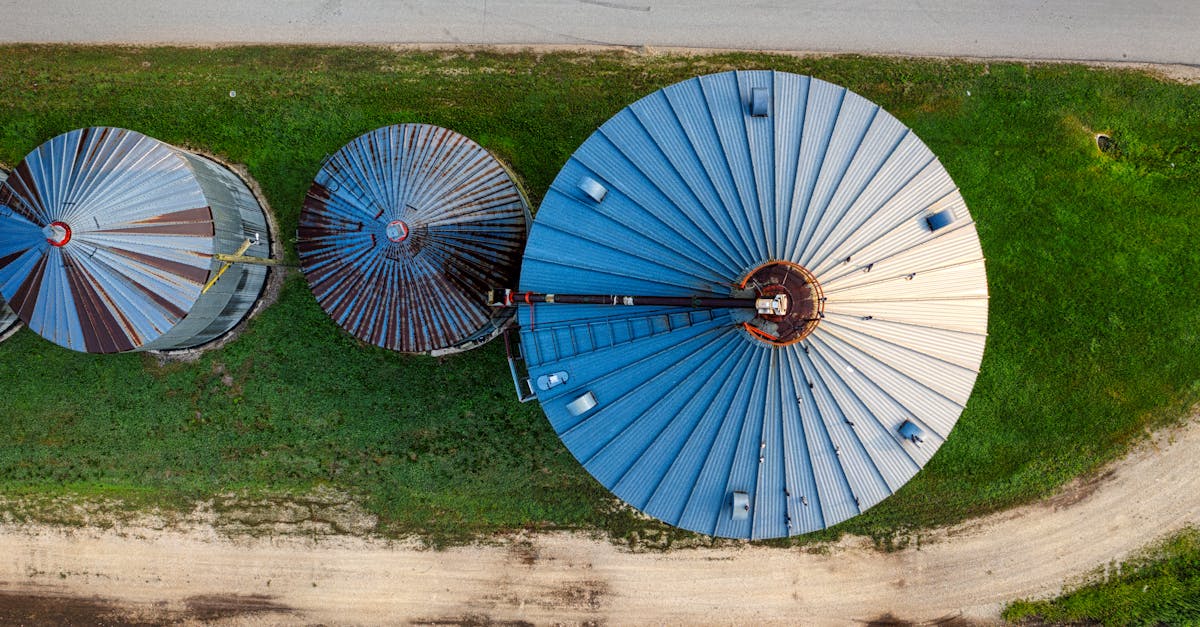 drone shot capturing top view of three large silos on a minnesota farm