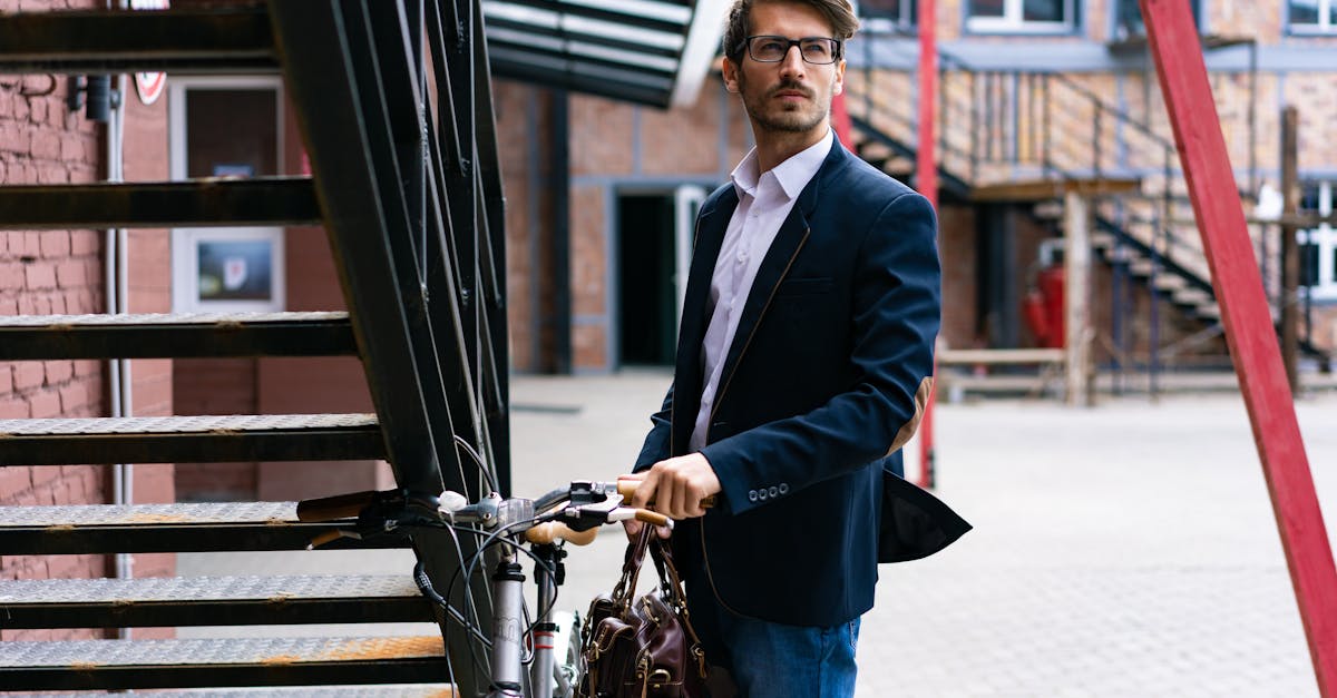 elegant businessman with bicycle in cityscape wearing a suit and carrying a briefcase