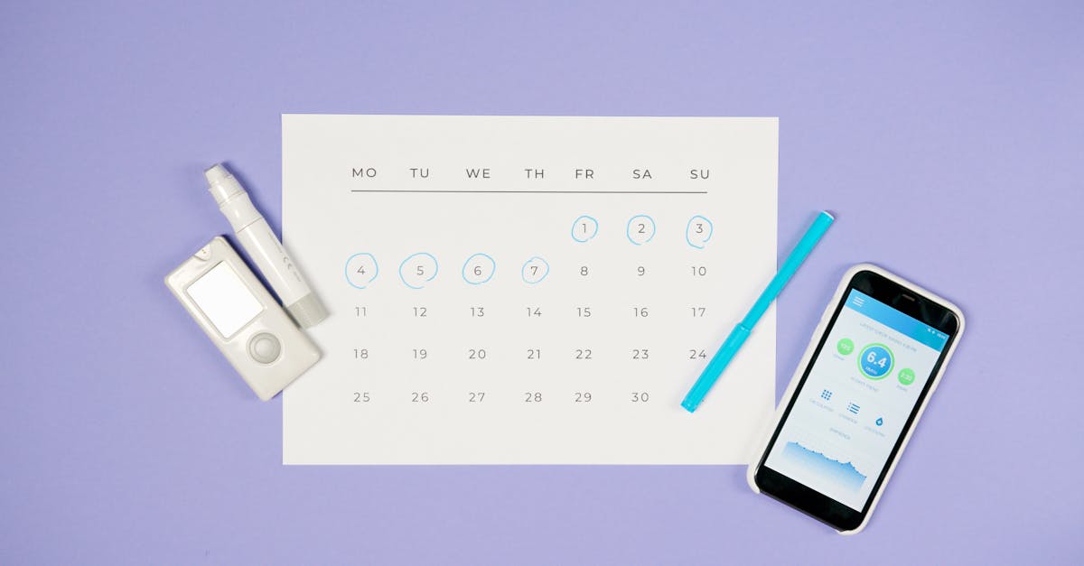 flat lay of calendar with medical devices and smartphone representing diabetes management