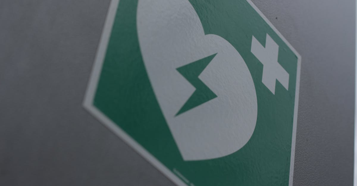 green first aid sign featuring a broken heart and cross symbol for medical emergency awareness