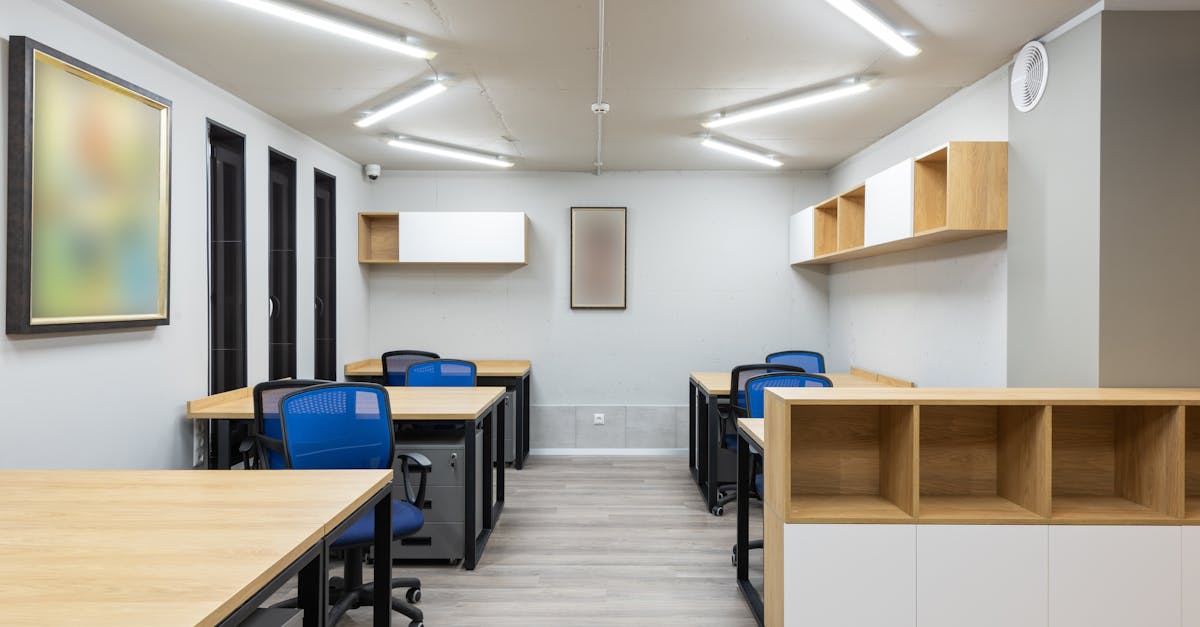 interior of contemporary workspace with office chairs at tables and wooden shelves under ceiling wit