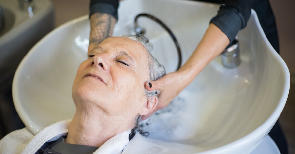 senior woman relaxing during a hair wash at a salon the hairstylist gently massages her hair in an