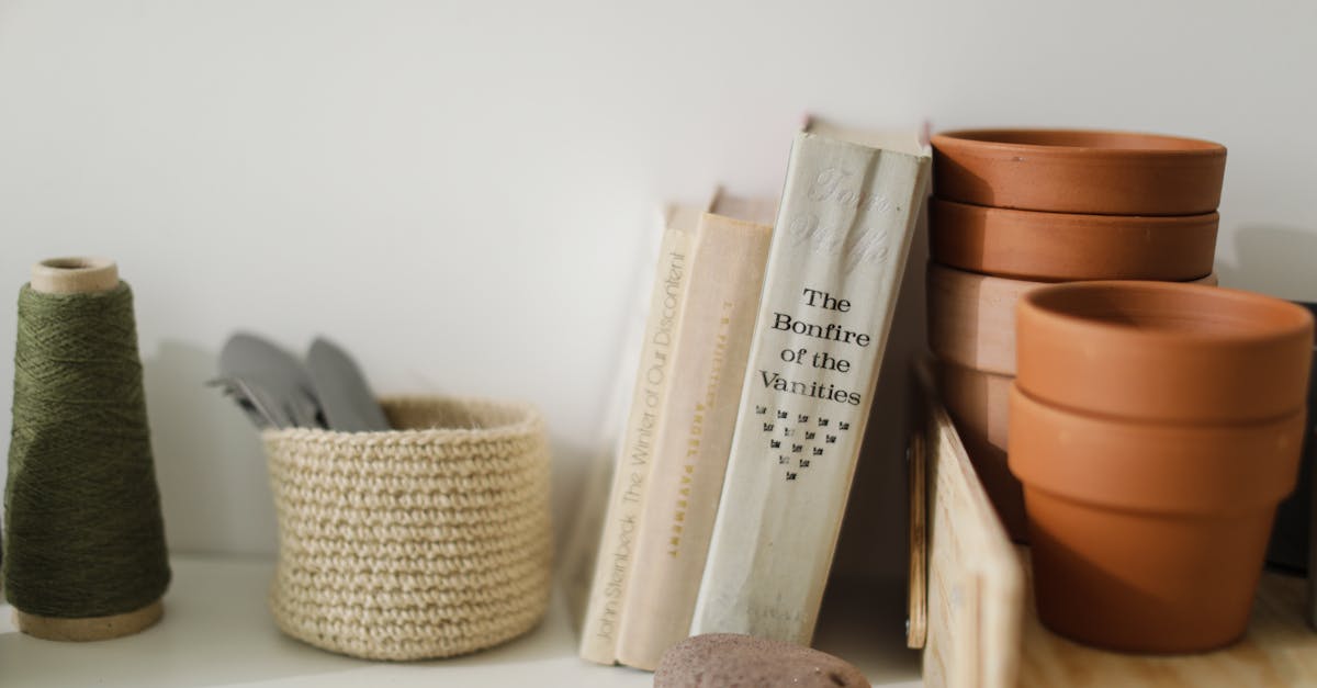 still life of crafting tools and books on a shelf with terracotta pots and thread 1