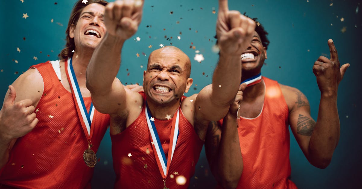 three athletes celebrating victory with medals and confetti against a blue background