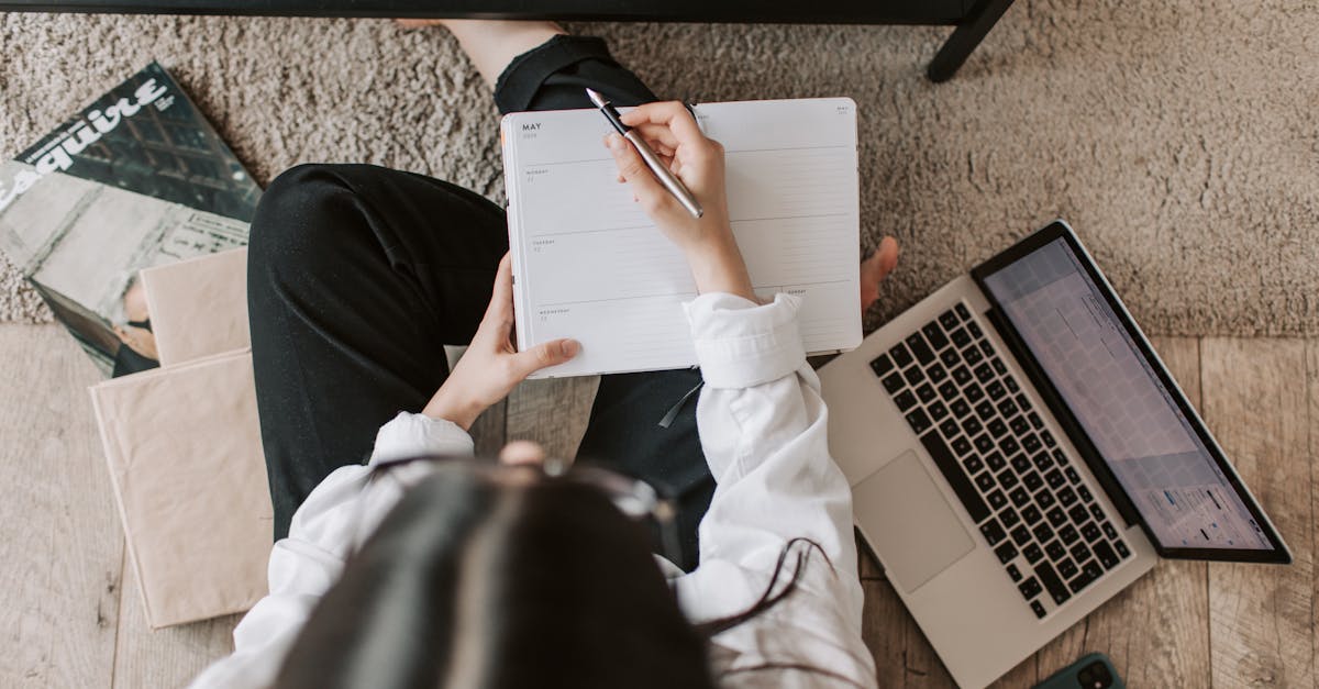 top view of anonymous woman in casual wear sitting on floor with laptop and smartphone and creating