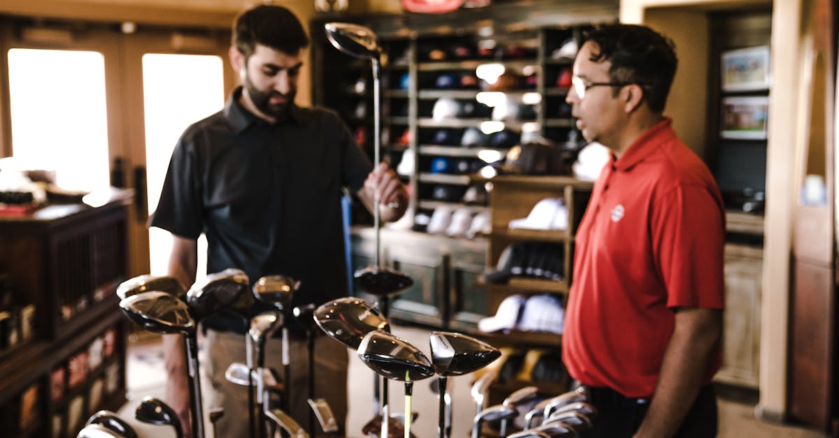 two men browsing golf clubs in a sports equipment store discussing options