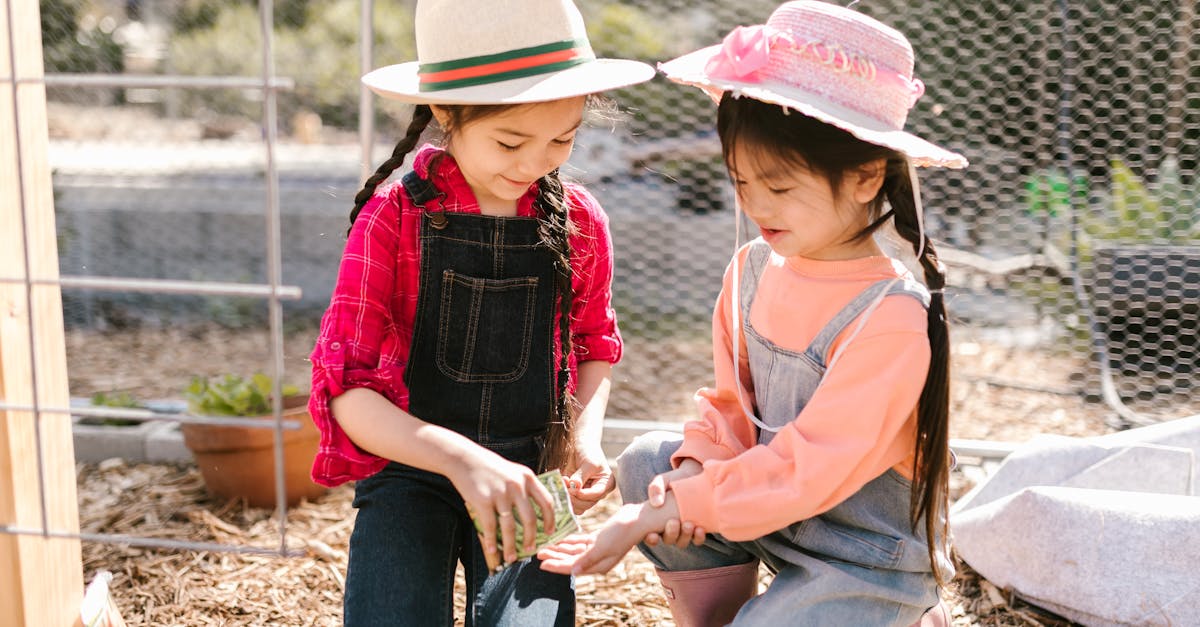 two young girls gardening together outdoors in sunny weather