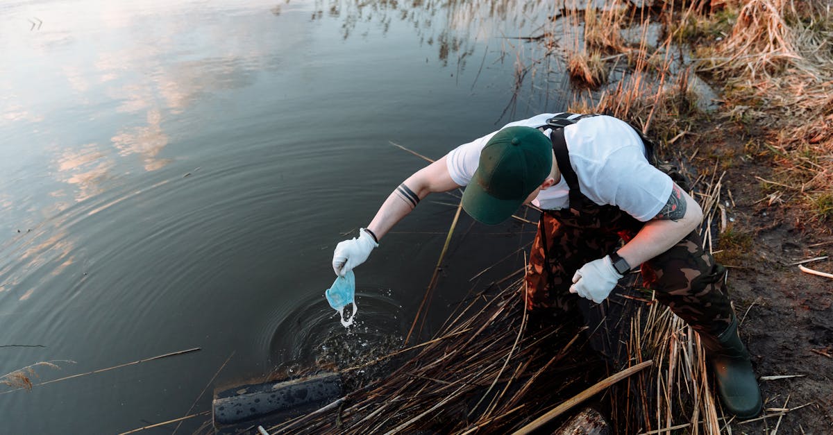 volunteer collecting trash along a lake to promote environmental conservation