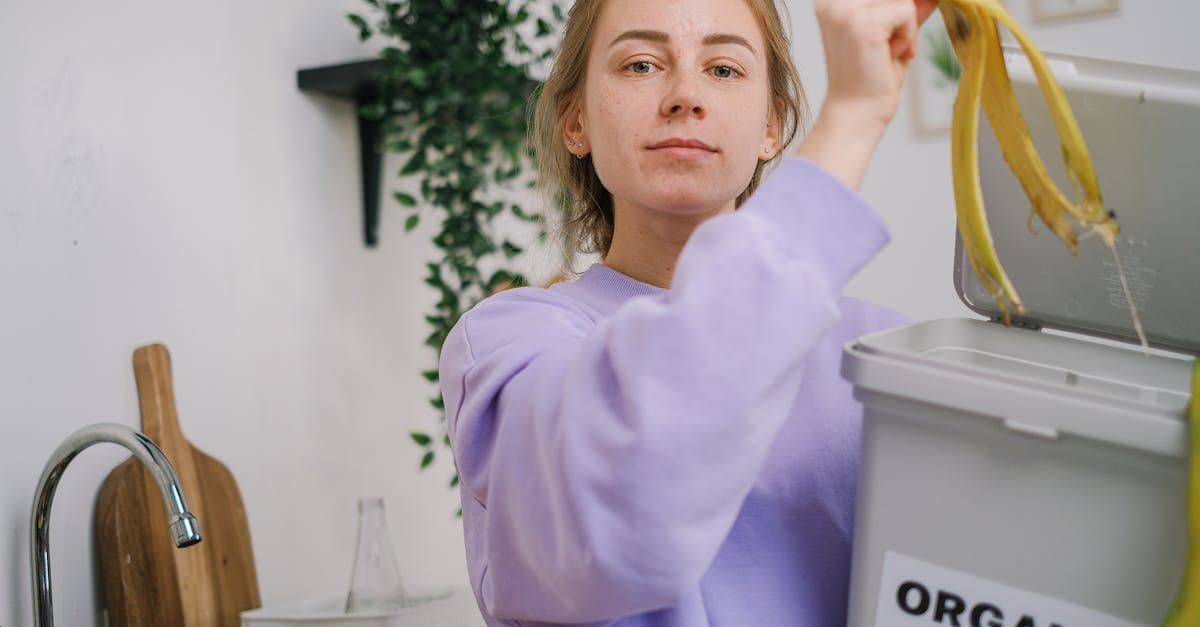 woman disposing banana peel in organic bin at home kitchen promoting eco friendly lifestyle