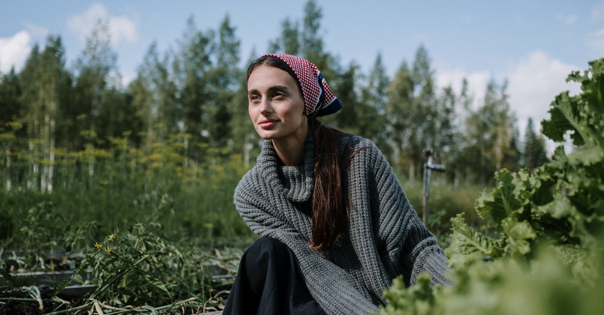 woman in a headscarf tending to a garden in a lush green setting outdoors with clear sky