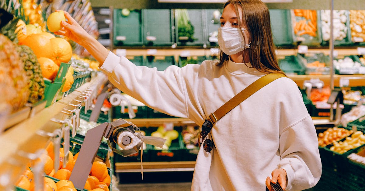 woman wearing a mask selecting fruit at a grocery store during pandemic 1